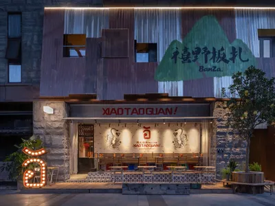 A modern Asian restaurant with a mountain theme, featuring a large dining area with multiple tables, benches, and warm lighting