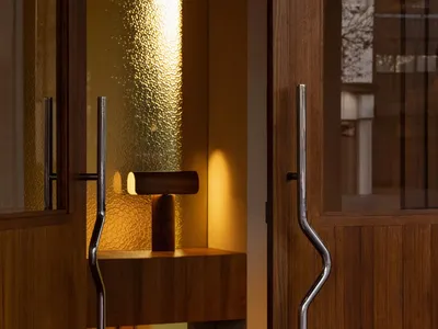 A doorway in a hotel lobby with a wooden frame, carpeted floor, and inviting atmosphere
