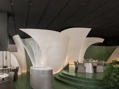白色圓頂結構的優雅餐廳空間，極簡設計，搭配餐桌、椅子與酒杯
