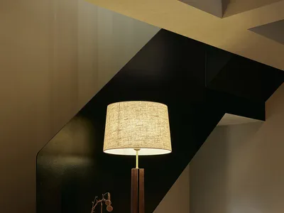 溫馨室內空間，黑色階梯、兩把椅子、一盞燈具與盆栽