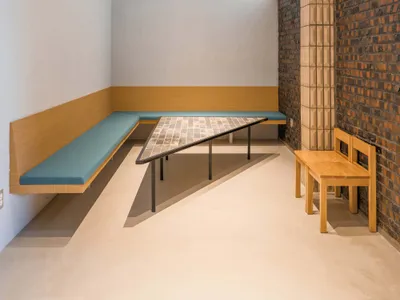溫馨客餐廳空間，配有兩張長椅、一張餐桌與椅子，周圍充滿溫暖親切的氛圍