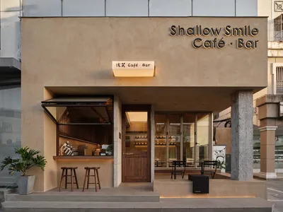 Spacious Asian restaurant with wood and concrete elements, comfortable seating, and potted plants