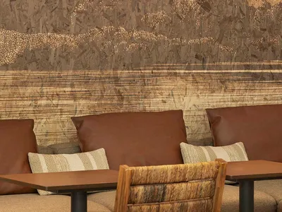 Warm and inviting living room with a tree in the center, featuring three chairs and a cozy atmosphere