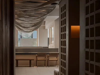 Cozy dining space with a tiled wall, multiple chairs, and benches, providing a warm atmosphere