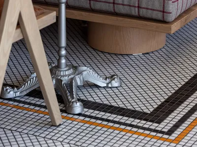 Cozy living space with a checkered tile floor, two chairs, and a dining table, creating a warm and inviting atmosphere