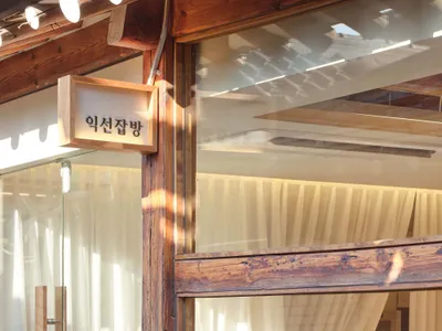 Warm and inviting Asian restaurant interior with a wooden door, window, and chairs around two dining tables