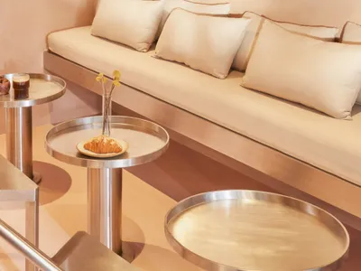 A modern living space with two couches, a dining table, and chairs, featuring neutral tones, clean lines, and a cozy atmosphere