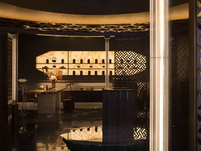 Elegant showroom with a round table, decorative bottles, and vases, featuring a sophisticated atmosphere and design elements