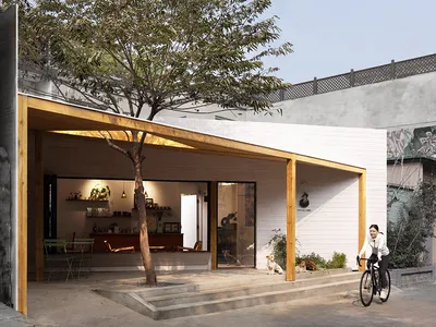 Casual open concept living area with a dining table, two chairs, and a bicycle parked outside