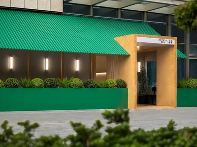 Vibrant Asian restaurant with a green awning, yellow decorations, and a city backdrop