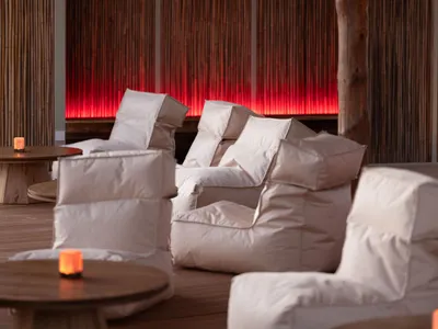 Cozy dining space with a large wooden beam, chairs, and a dining table, creating a warm atmosphere