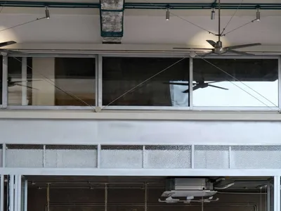 Casual kitchen with dining area, featuring a dining table, chairs, appliances, and scattered bottles, with a focus on functionality and convenience
