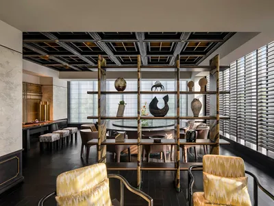 光線充足的餐廳區域，配有多張椅子、餐桌，以及架上裝飾花瓶，展現多種風格與設計