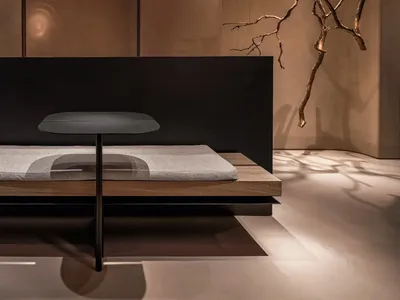 現代臥室配黑色床架、木質床頭、灰色毛毯、餐桌、兩把椅子及盆栽，打造開放式生活空間