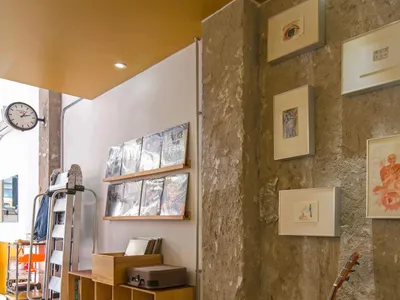 A cozy room with a guitar on the wall, books scattered around, and a chair in the corner, creating a relaxing atmosphere for music enthusiasts