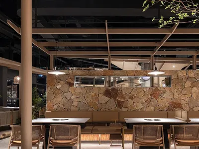A modern dining area with multiple tables and chairs in various styles, set against a neutral background
