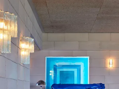 A serene blue bedroom with a blue bed, two lamps, and a calm atmosphere