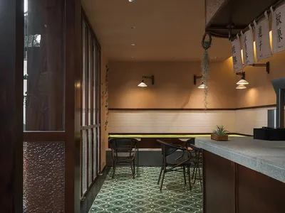 溫暖親切的餐廳內部，米色牆面、盆栽，以及桌椅用餐區