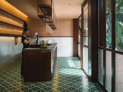餐廳廚房內有木質櫥櫃、磁磚地板與各式廚具，包括盆栽，周圍有兩人環繞