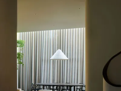 一間設有餐桌椅、沙發，並營造溫馨氛圍的餐廳，適合社交與用餐