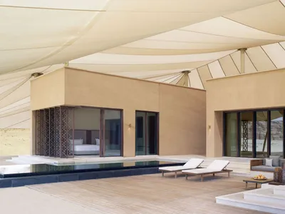 Open living area with wooden deck, pool, and comfortable seating arrangement, surrounded by a relaxing atmosphere