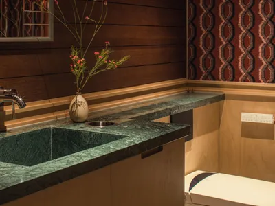 Bathroom scene with a sink, mirror, vases, and potted plants, creating a cozy and inviting atmosphere