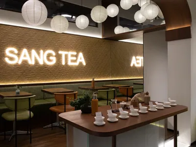 溫馨餐廳內部，配有木質餐桌、椅子與杯具，周圍環繞暖光燈與舒適氛圍