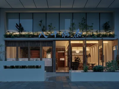 Modern Asian restaurant with a glass door, wooden furniture, and metal accents, featuring a stylish and elegant atmosphere