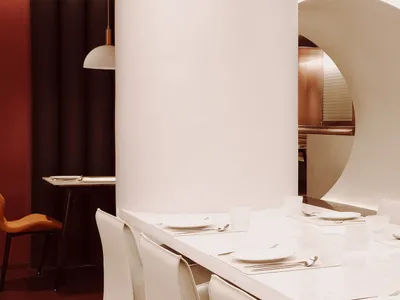 餐廳內的用餐區，白色餐桌擺放精緻瓷器、酒杯與各式餐具，營造出高雅氛圍