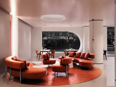 A modern restaurant lounge with orange chairs and tables, circular shape, and inviting atmosphere