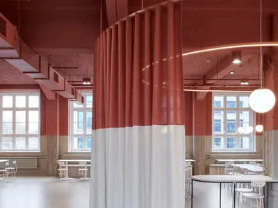 紅白牆面的現代餐廳內部，多張餐桌與椅子，展現乾淨線條與極簡設計元素