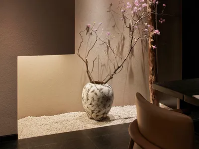 溫馨客廳空間內有石瓶、兩把椅子與餐桌，營造溫暖氛圍