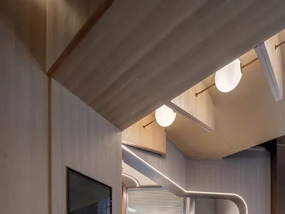 工業風格餐廳內部，設有通往廚房區的樓梯，廚房區包含兩台冰箱與水槽