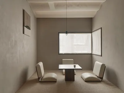Dimly lit living area with a dining table and chairs, minimalistic design, and a cozy seating arrangement