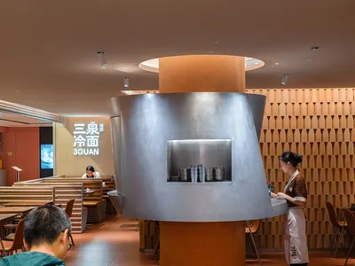 A modern Asian restaurant with dining tables, chairs, and wood paneling, creating a warm and inviting atmosphere