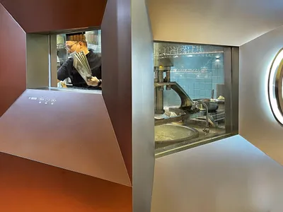 工業風廚房分為兩區，以牆面分隔，包含料理台、家電與烹飪用品
