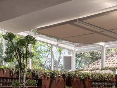現代餐廳內部，設大型餐桌、椅子、盆栽植物與柔和暖光照明