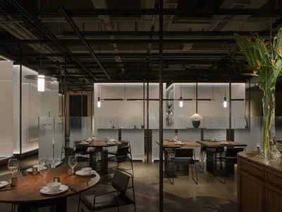 夜晚寧靜餐廳內部，木質地板、桌上酒杯與優雅設計元素