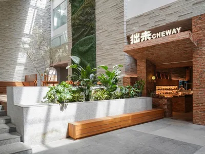 Cozy Asian restaurant with a brick exterior, dining tables, potted plants, and a welcoming atmosphere