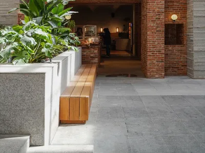 Cozy Asian restaurant with a brick facade, wooden interior, potted plants, and comfortable seating areas