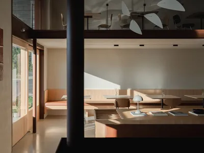 Modern dining space with a dining table, chairs, and a kitchen area, featuring a cozy atmosphere and comfortable seating