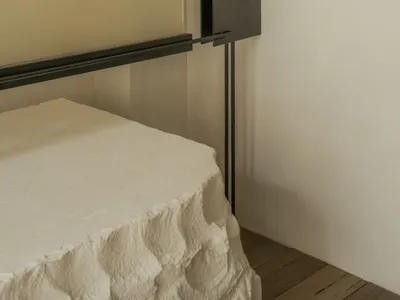 Modern bedroom with a black metal frame on a white wall, creating a striking contrast