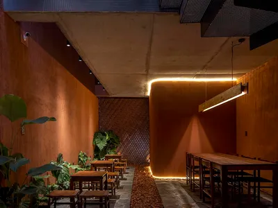 A well-lit dining area with several tables and chairs, suggesting a modern restaurant design