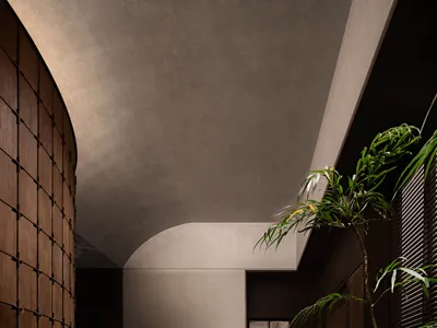 A well-lit hotel hallway with a wooden floor, arched doorway, potted plants, and a bench, creating a warm atmosphere