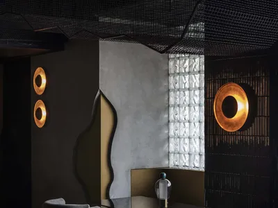 Modern restaurant interior with tables, chairs, decorative elements, and a bar, featuring a unique design theme with circles and squares