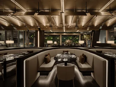 A modern restaurant with white chairs and tables, clean and inviting atmosphere, warm lighting, and a contemporary feel