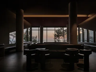 Modern restaurant interior with open seating area, clean lines, and minimalistic elements, featuring dining tables and chairs