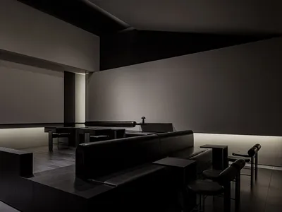 Dark and moody restaurant with black leather seating, grey tones, and a sophisticated ambiance