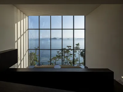 A serene living space with ocean views, black countertops, and potted plants, creating a relaxing atmosphere