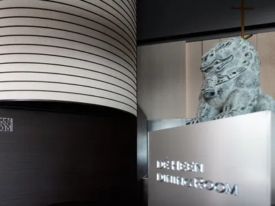 優雅的室內設計，以大型龍雕像置於條紋牆前，營造精緻氛圍，展現亞洲文化影響